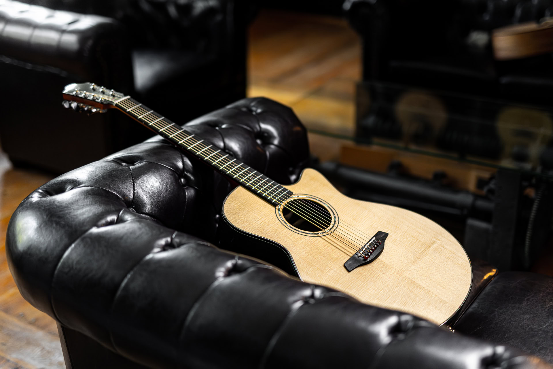 Kytara odložená na koženém křesle